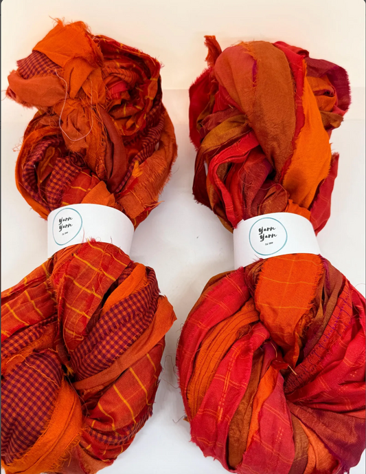 Sari silk ribbon yarn in sanguine orange for fibre arts and crafts.
